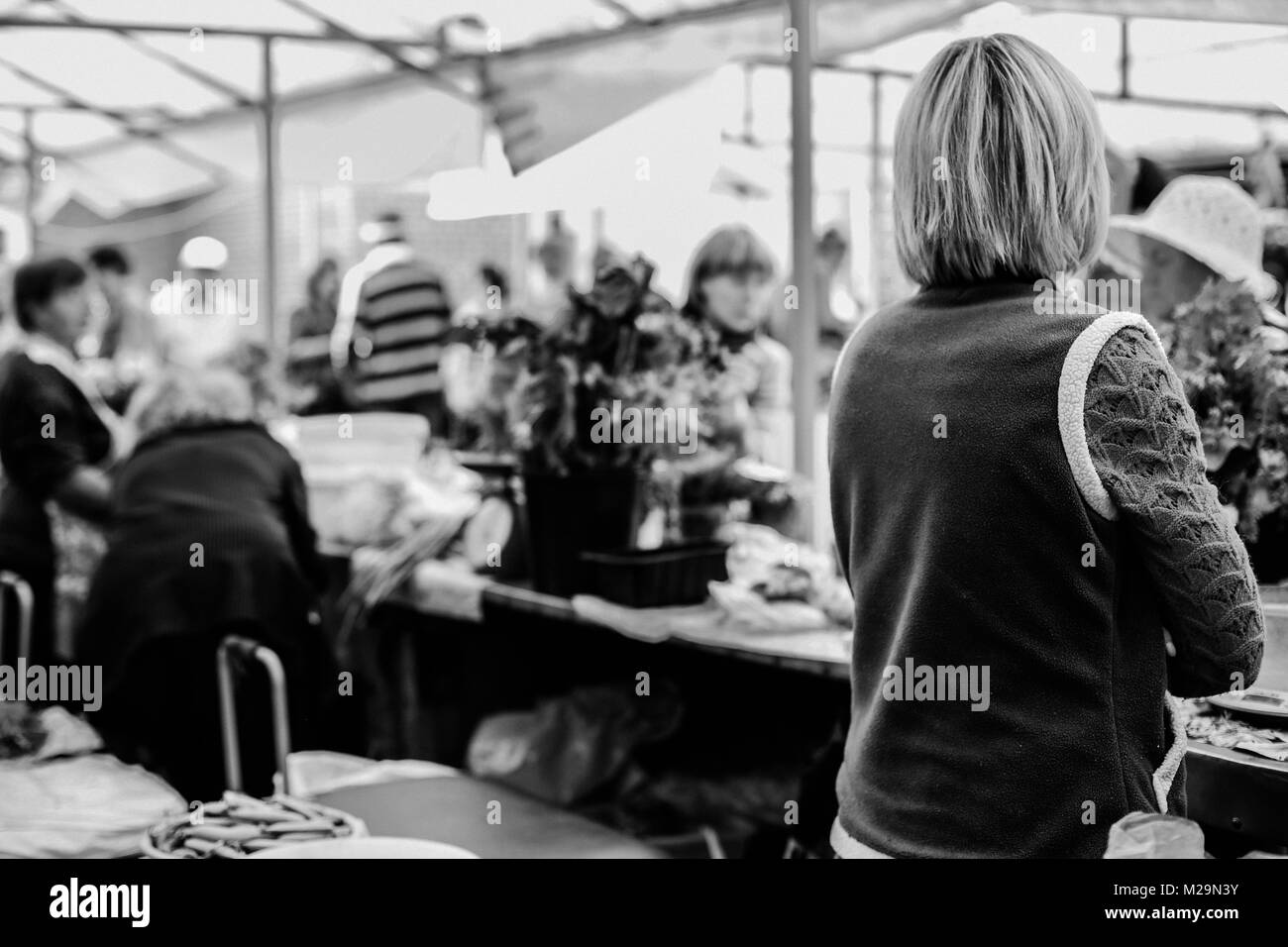 Gli agricoltori locali del mercato. Prodotti freschi: verdure, bacche, fiori selvatici. Le persone anziane l'acquisto di generi alimentari. Scale, casse, scatole. Vilnius, Lituania. Foto Stock