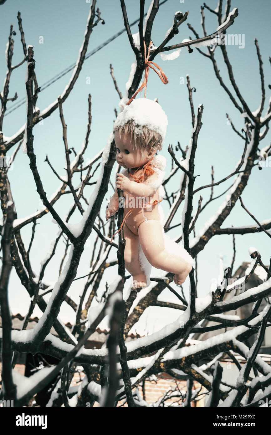 Coperte di neve lo spaventapasseri su un albero in un vecchio villaggio Foto Stock