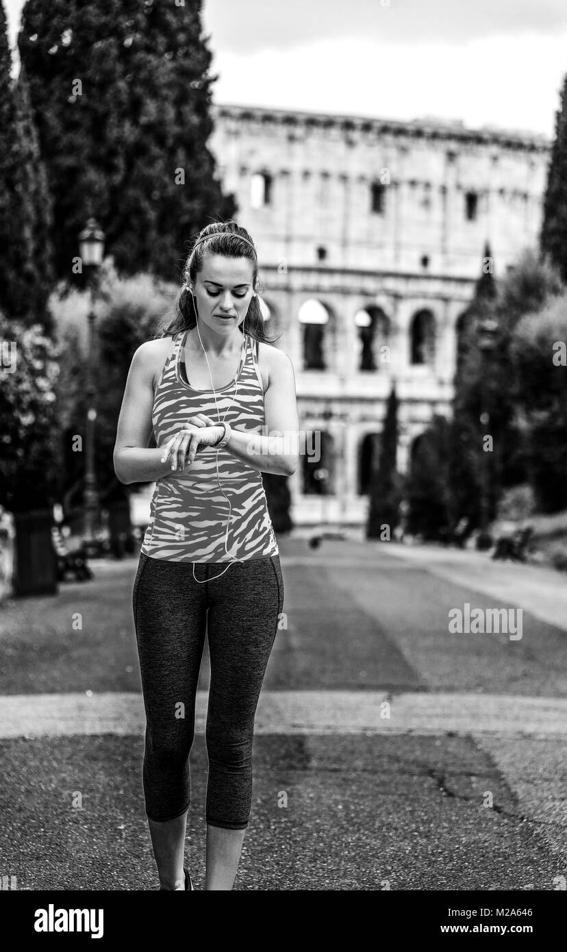 Gladiator ispirando allenamenti. giovane donna nel pareggiatore sportswear in Italia a Roma con bracciale fitness Foto Stock