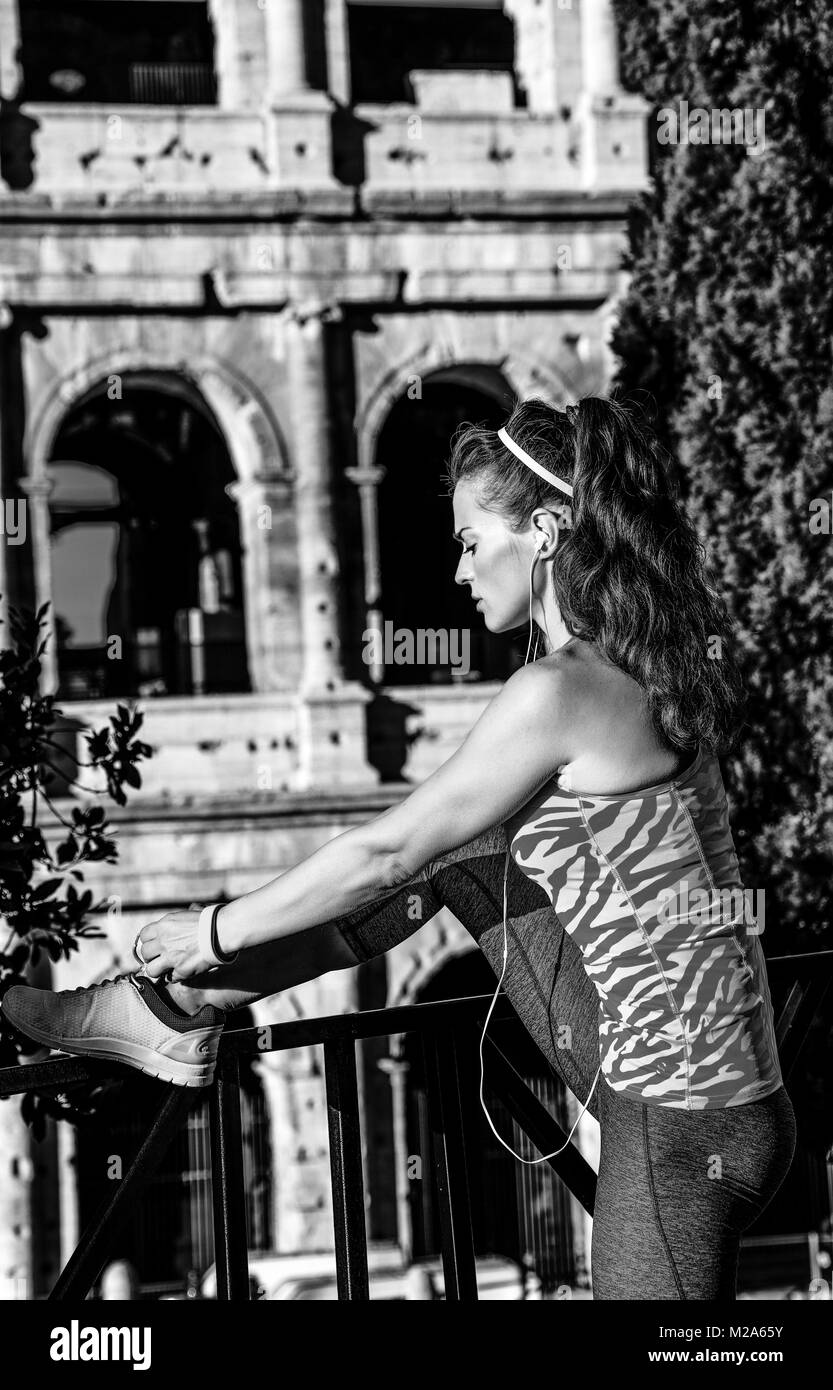 Gladiator ispirando allenamenti. elegante donna attiva nell'abbigliamento  sportivo vicino a Colosseo a Roma, Italia lacci delle scarpe di legatura  Foto stock - Alamy