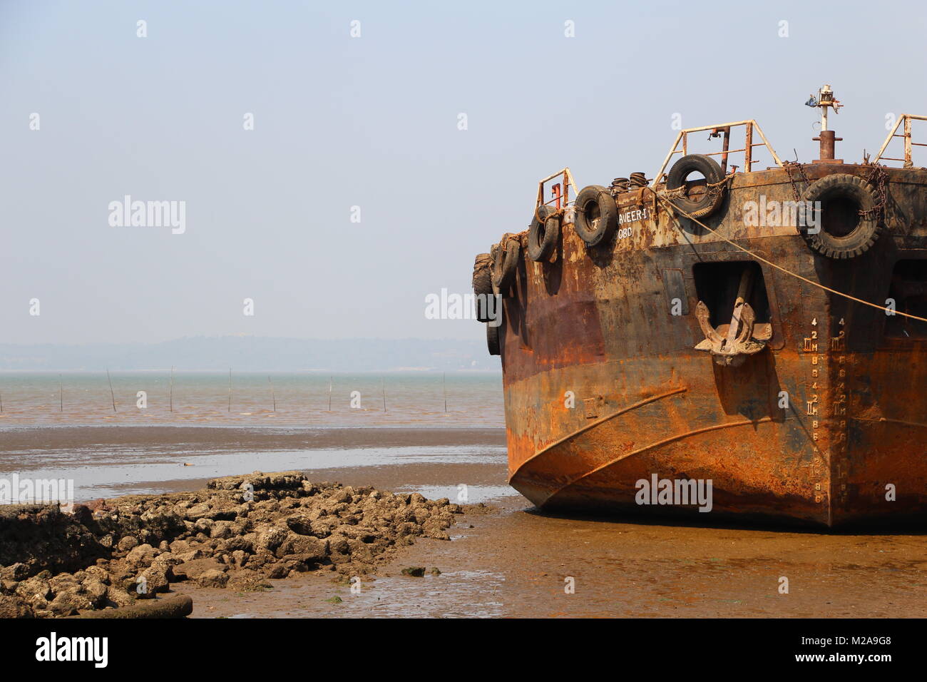 Rusty shipwrack sul terreno di una bassa marea aral Foto Stock