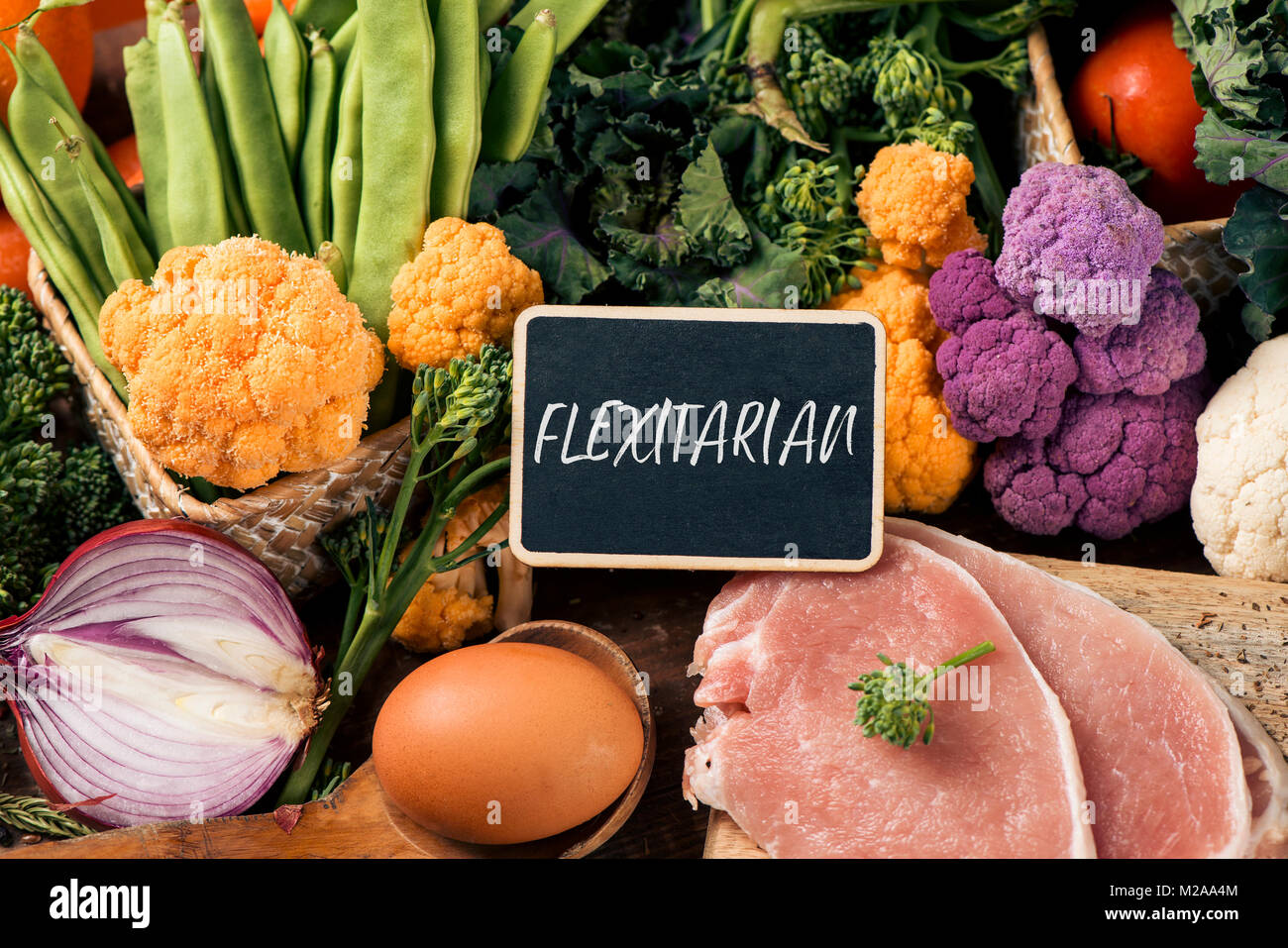 Primo piano di un cartello con scritto il testo flexitarian su una pila di alcune diverse verdure crude, come i cavolfiori di diversi colori, broccolini, o f Foto Stock