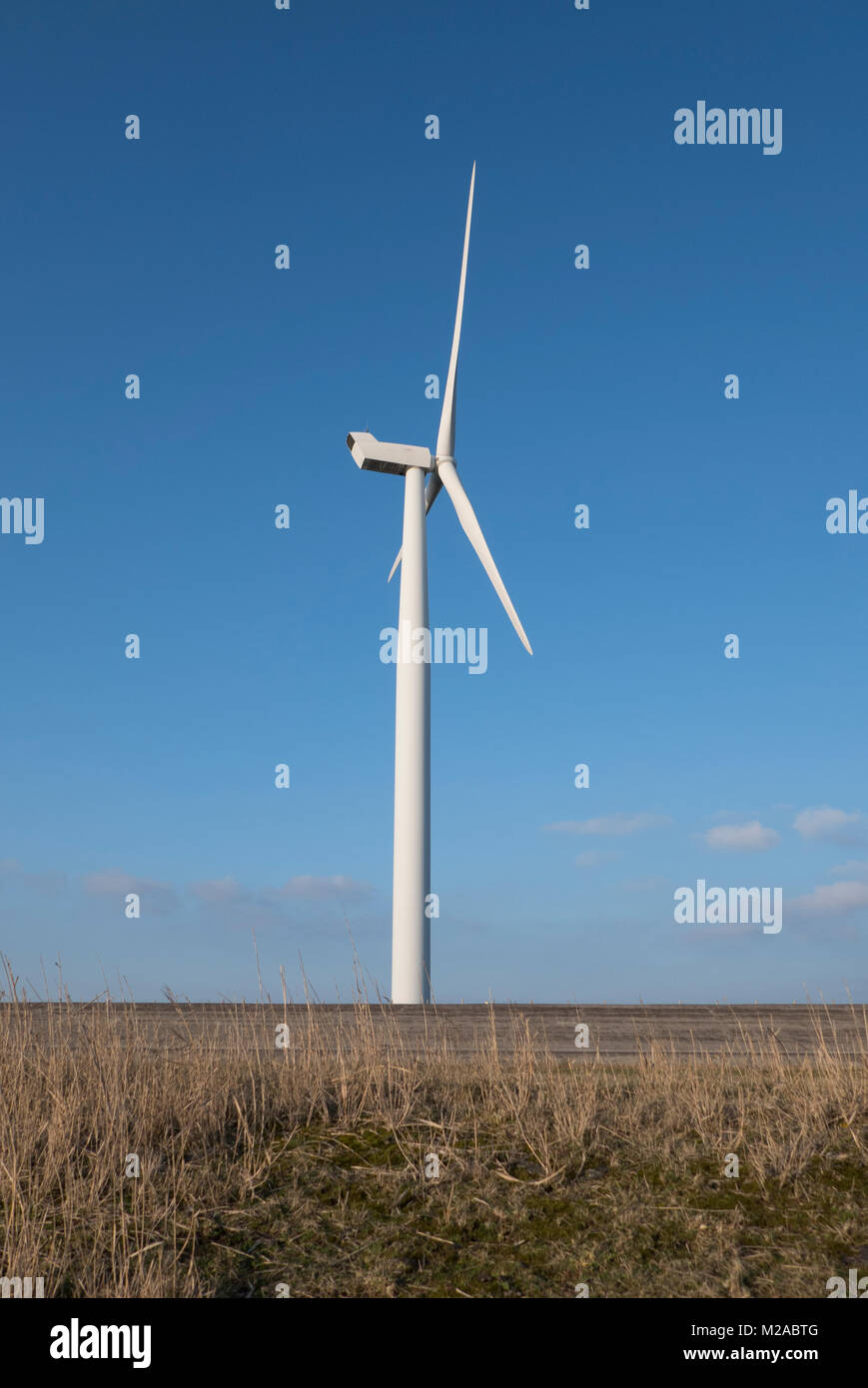 Turbina eolica per la generazione di elettricità con cielo blu in Herkingen in Olanda vicino al lago grevelingen dove loro catture più vento Foto Stock