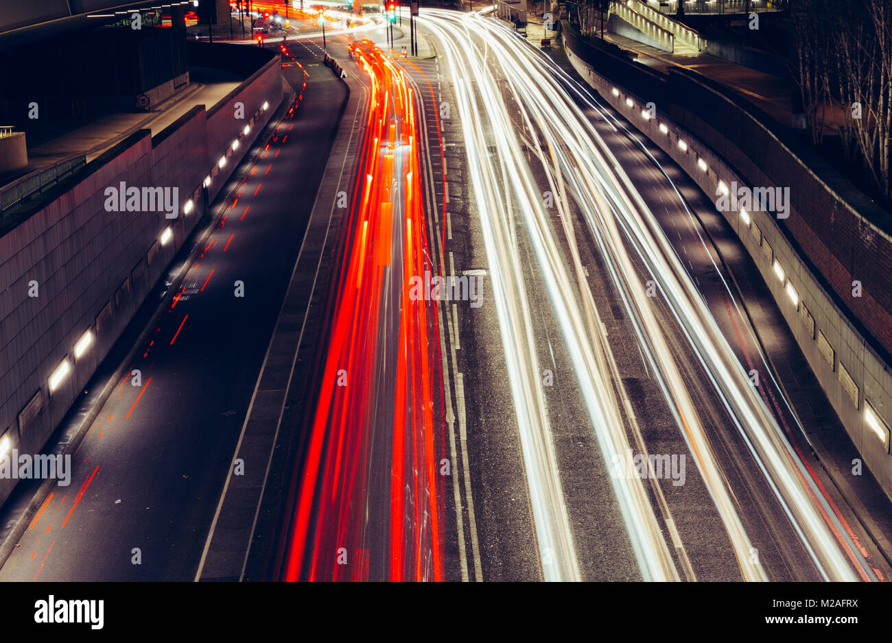 Città percorsi di luce di veloce vettura in movimento il traffico su strada in Londra di notte Foto Stock