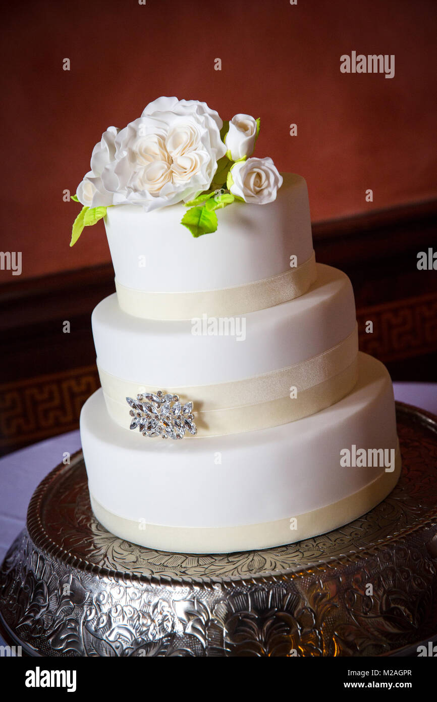 Tre livelli di glassa bianca torta di nozze con iced decorazioni di fiori Foto Stock