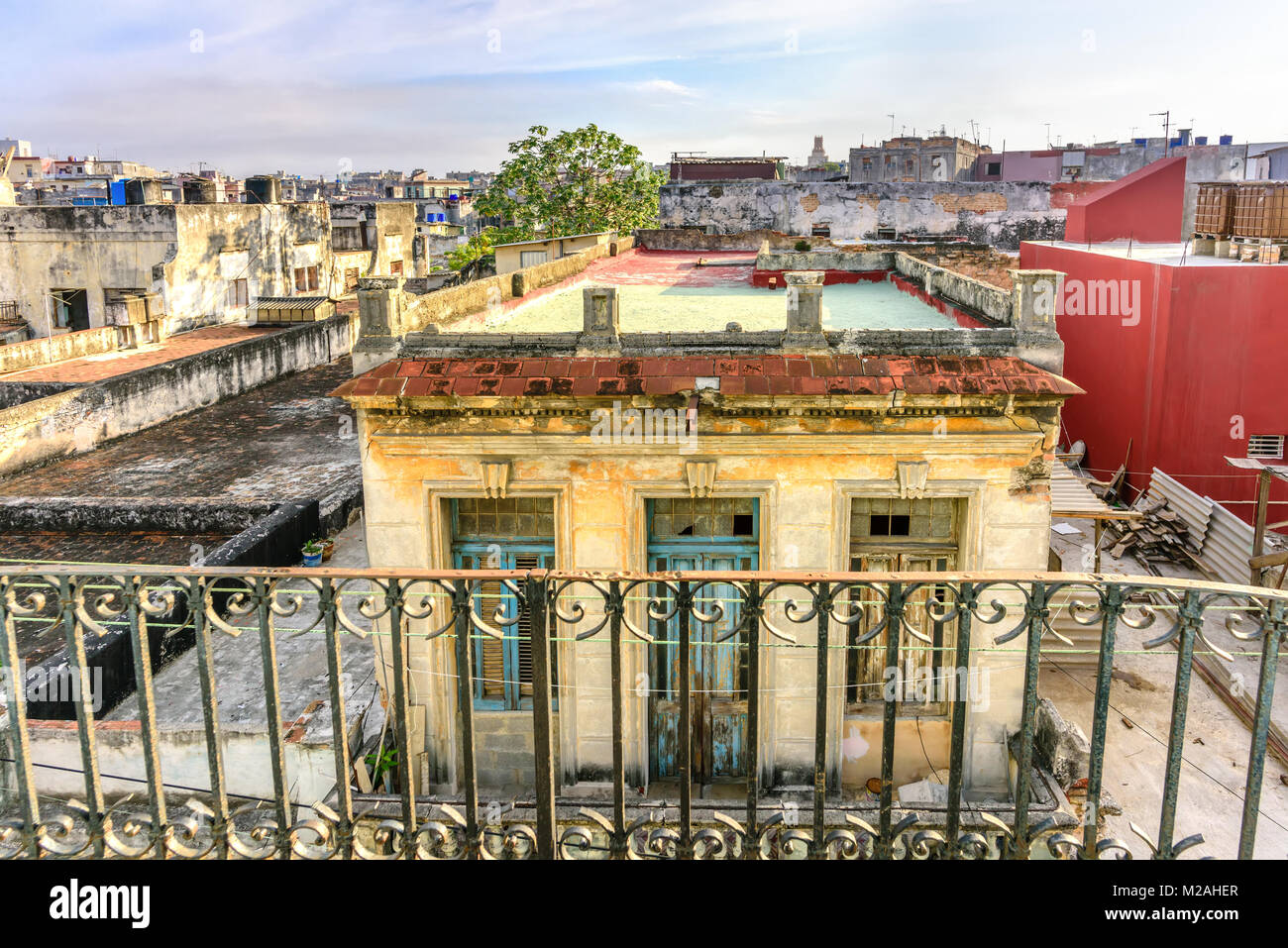 Vista dal balcone sui tetti della vecchia, fatiscente, sfoglia edifici e un colore grigio-blu del cielo nella baraccopoli zona in Havana in Cuba Foto Stock