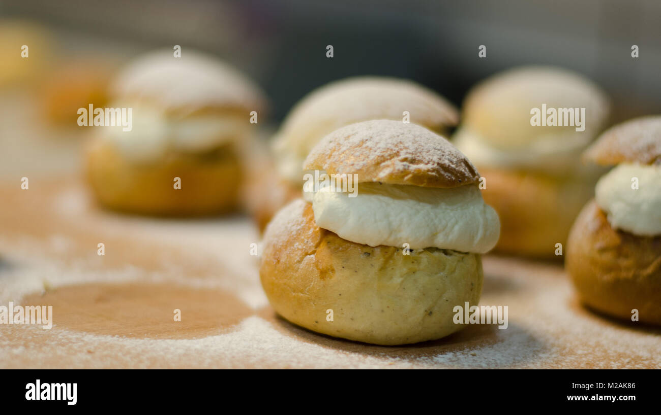 Il tradizionale shrovetide bun - semla su un tagliere con spolverata di zucchero. Foto Stock