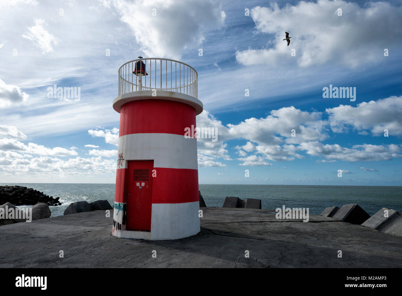 Red & White striped lighthouse / navigazione mark all'ingresso di un porto Foto Stock