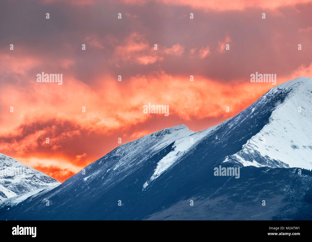 Rosso brillante tramonto Grisedale Pike, Coledale Ferro di Cavallo e il nord del Lake District, preso da Applethwaite. Foto Stock