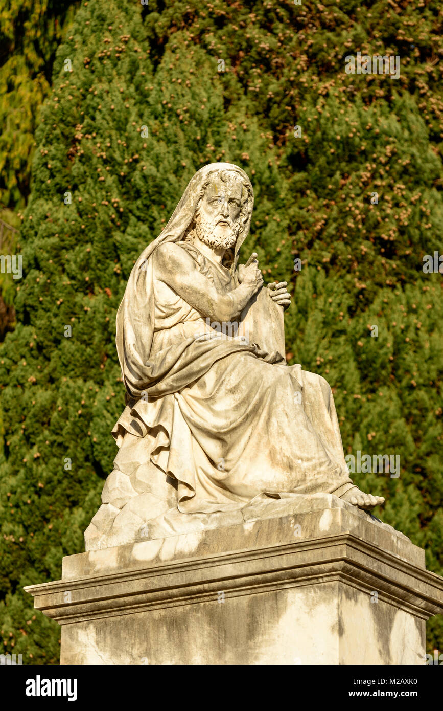 La scultura in pietra di vecchio uomo a storico monumentale cimitero di Staglieno in città, girato in condizioni di intensa luce invernale in Genova, liguria, Italy Foto Stock