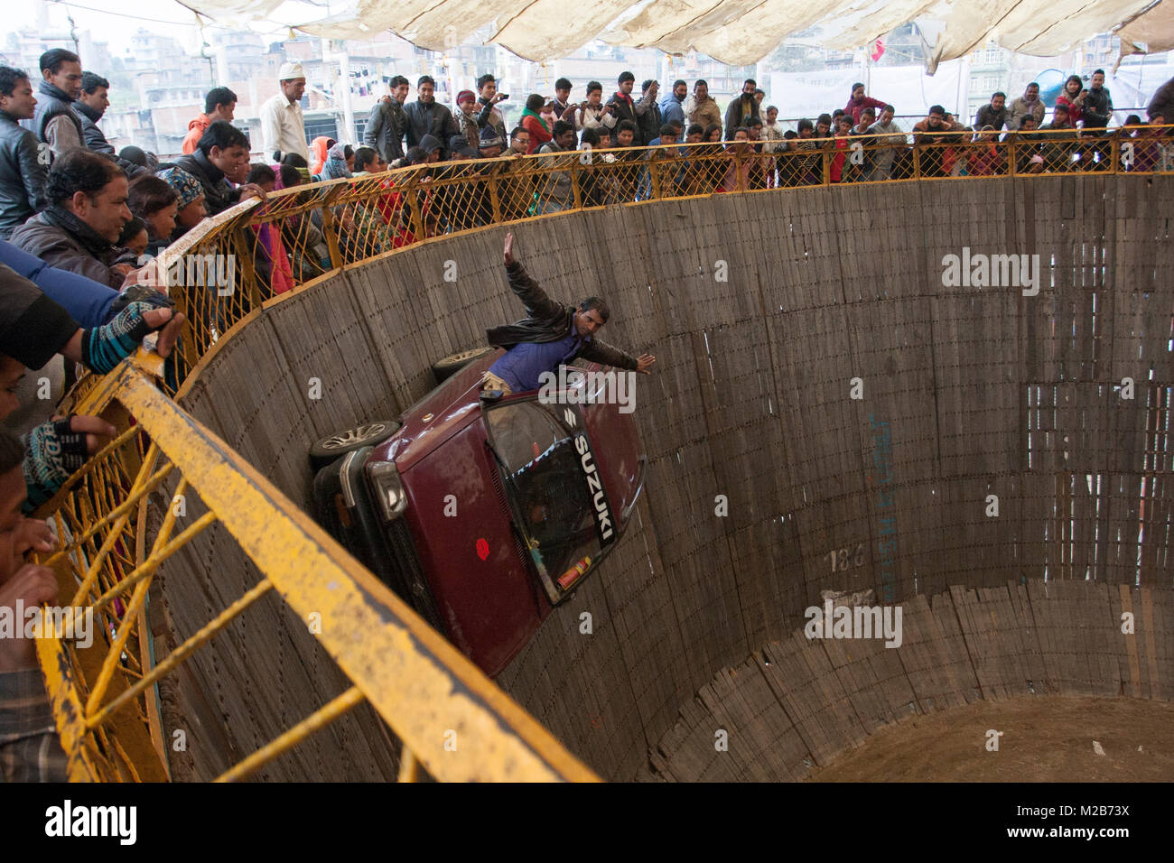 Un uomo compie auto stunt in un circo chiamato morte del recipiente in Nepal. Foto Stock
