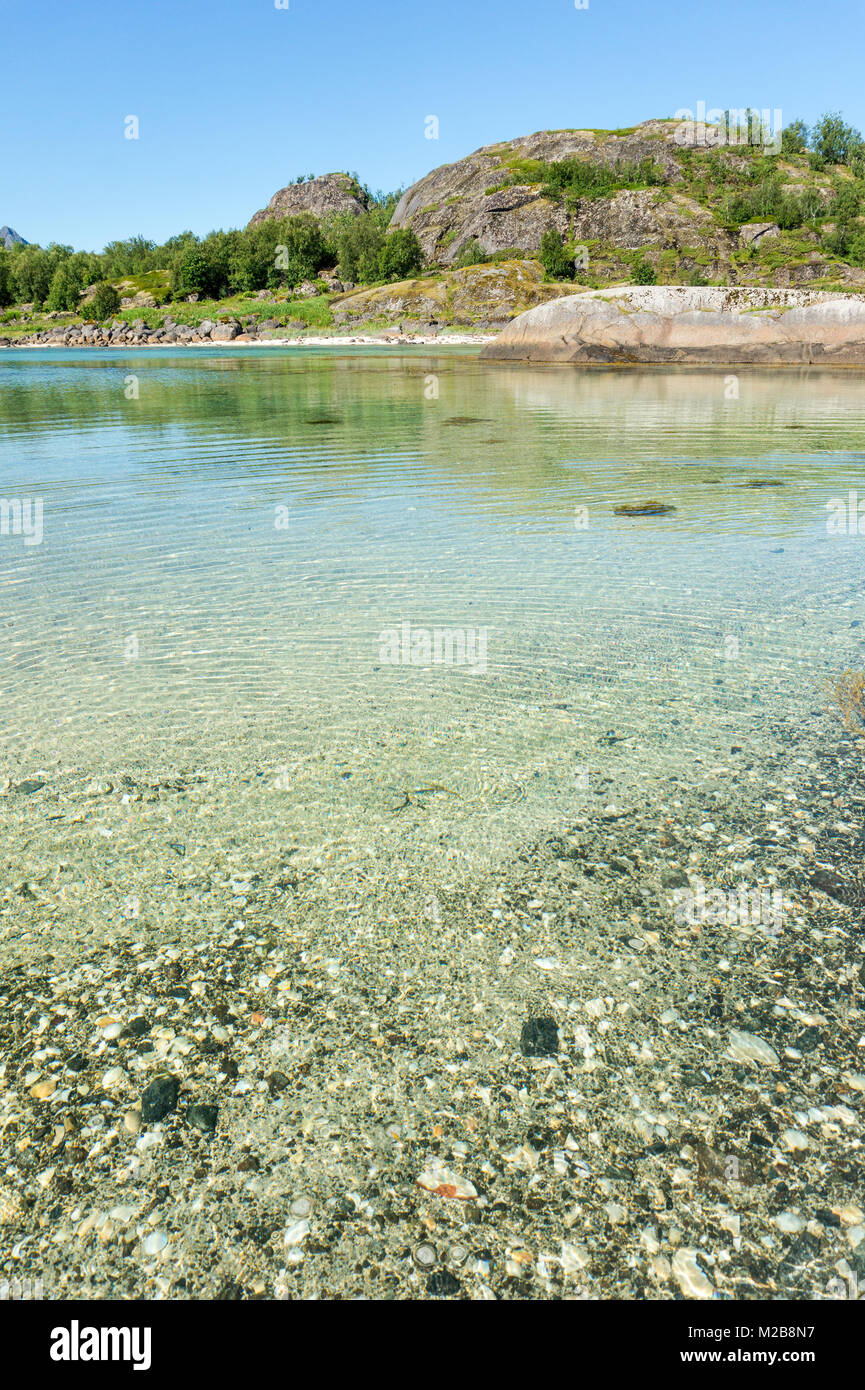 L'acqua turchese, verdi colline e pietre, arcipelago delle Lofoten, Norvegia, Arsteinen isola Foto Stock