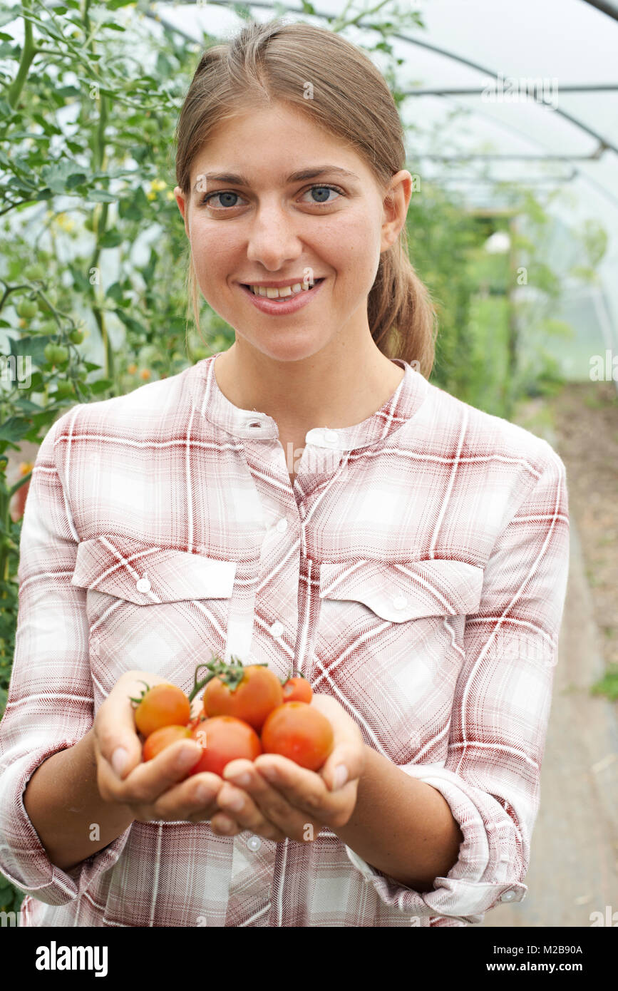 Ritratto di donna lavoratrice agricola Controllo di piante di pomodoro in serra Foto Stock