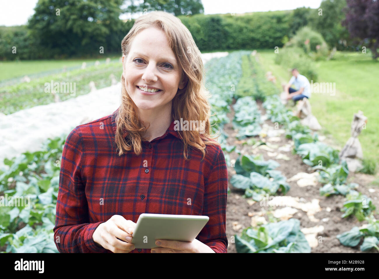 Ritratto di donna lavoratrice agricola con tavoletta digitale nel campo Foto Stock