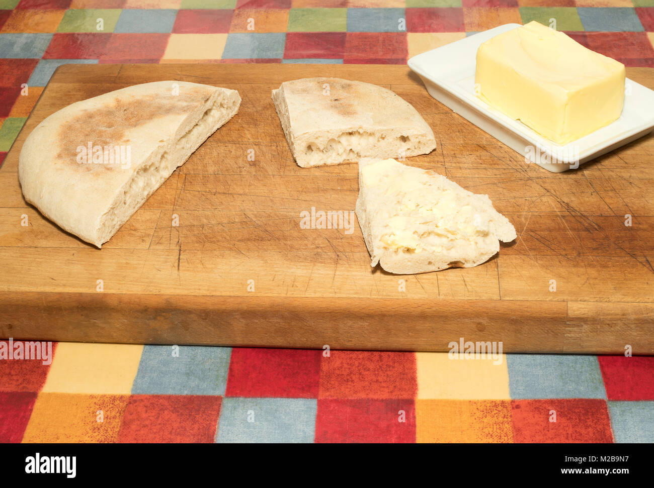 Un stottie di stotty torta tagliata pronto per servire con una fetta imburrata, North East England, Regno Unito Foto Stock