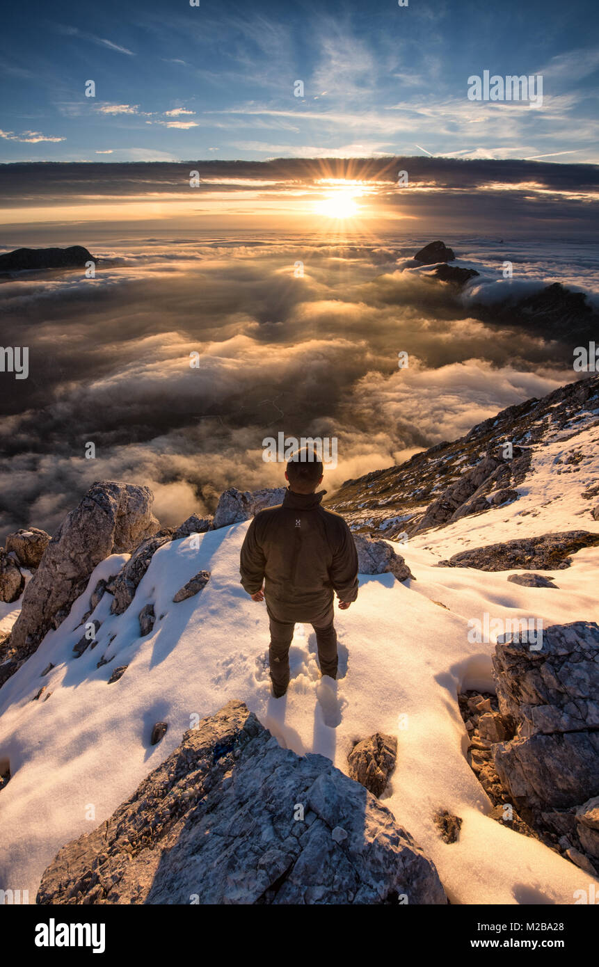 Un trekker ammirate il tramonto, al di sopra di un magnifico mare di nuvole nelle Alpi. La foto è stata presa sulla parte superiore del Foronon dal Buinz mountain (2531m). Foto Stock