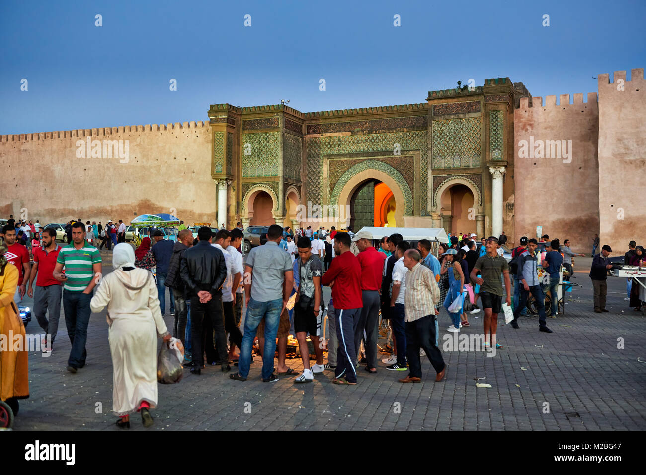 La gente sulla piazza Lahdim con Bab Mansour city gate dietro , Meknes, Marocco, Africa Foto Stock