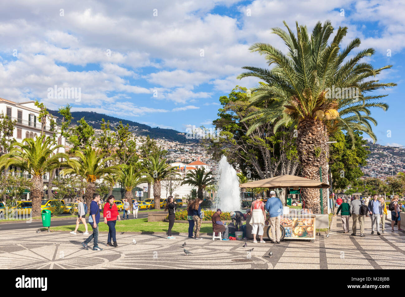 MADEIRA PORTOGALLO MADEIRA Funchal turisti vagare passato le fontane e una bancarella vendendo castagne calde sul lungomare di Funchal Madeira Foto Stock