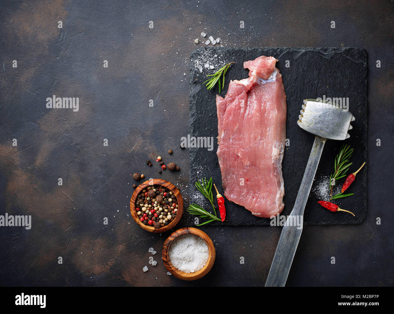 La carne cruda di manzo con spezie su sfondo arrugginito Foto Stock