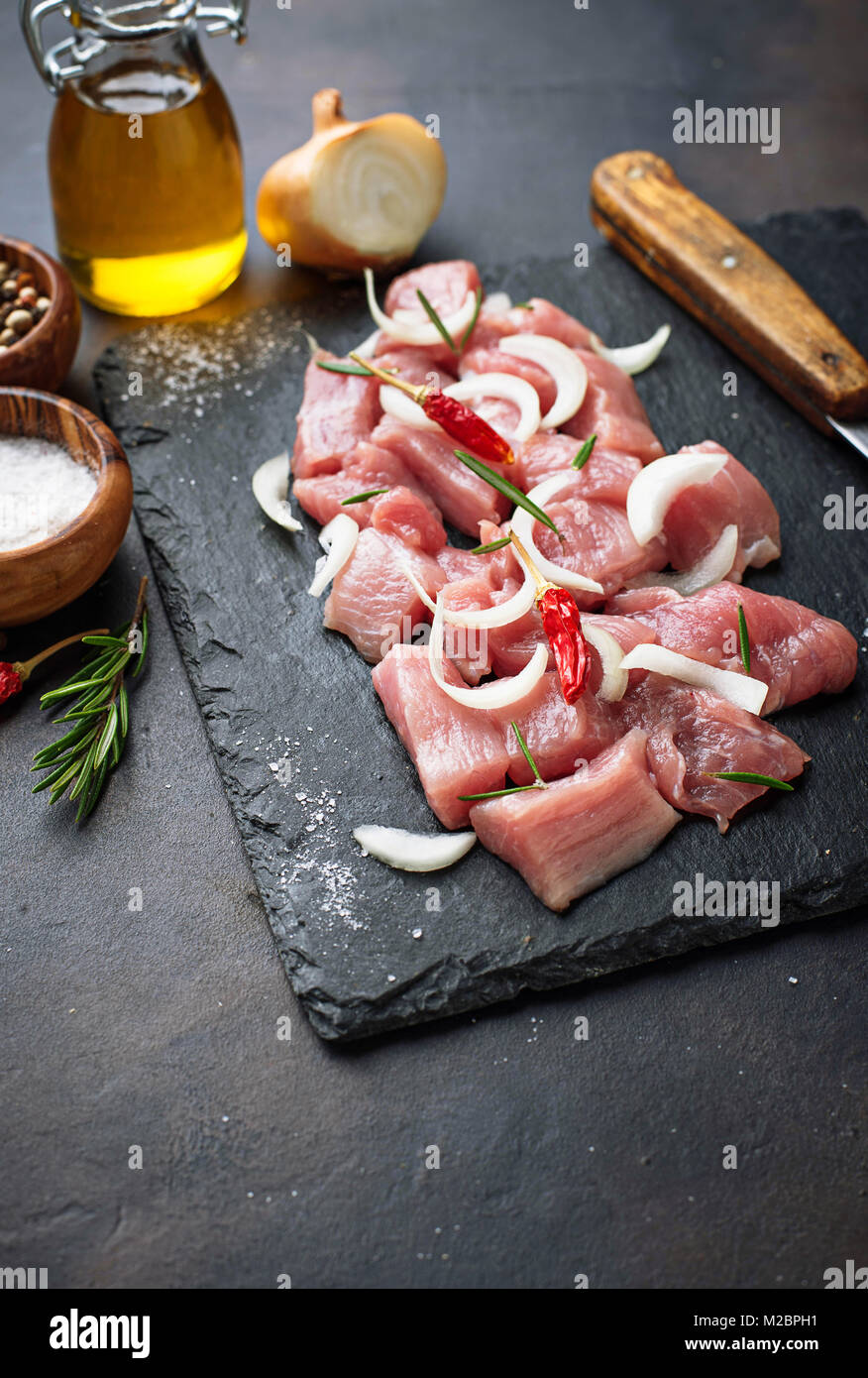 Materie carne tritata con spezie su sfondo arrugginito Foto Stock