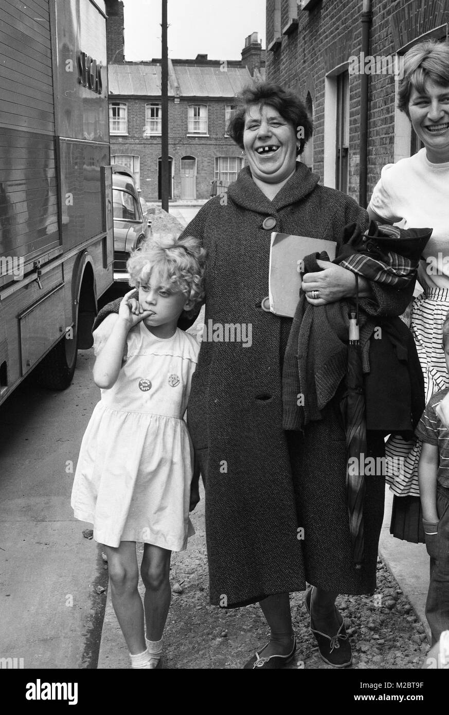 Donna e bambino a casa a piedi dalla scuola in Deptford Londra 1968 Foto Stock