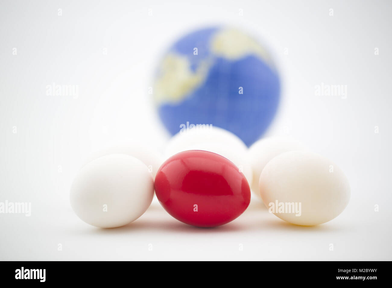 Rischi e pericoli sono naturale nel mercato globale degli investimenti e sono visibili in rosso uovo collocato con nido di ordinaria uova. Foto Stock