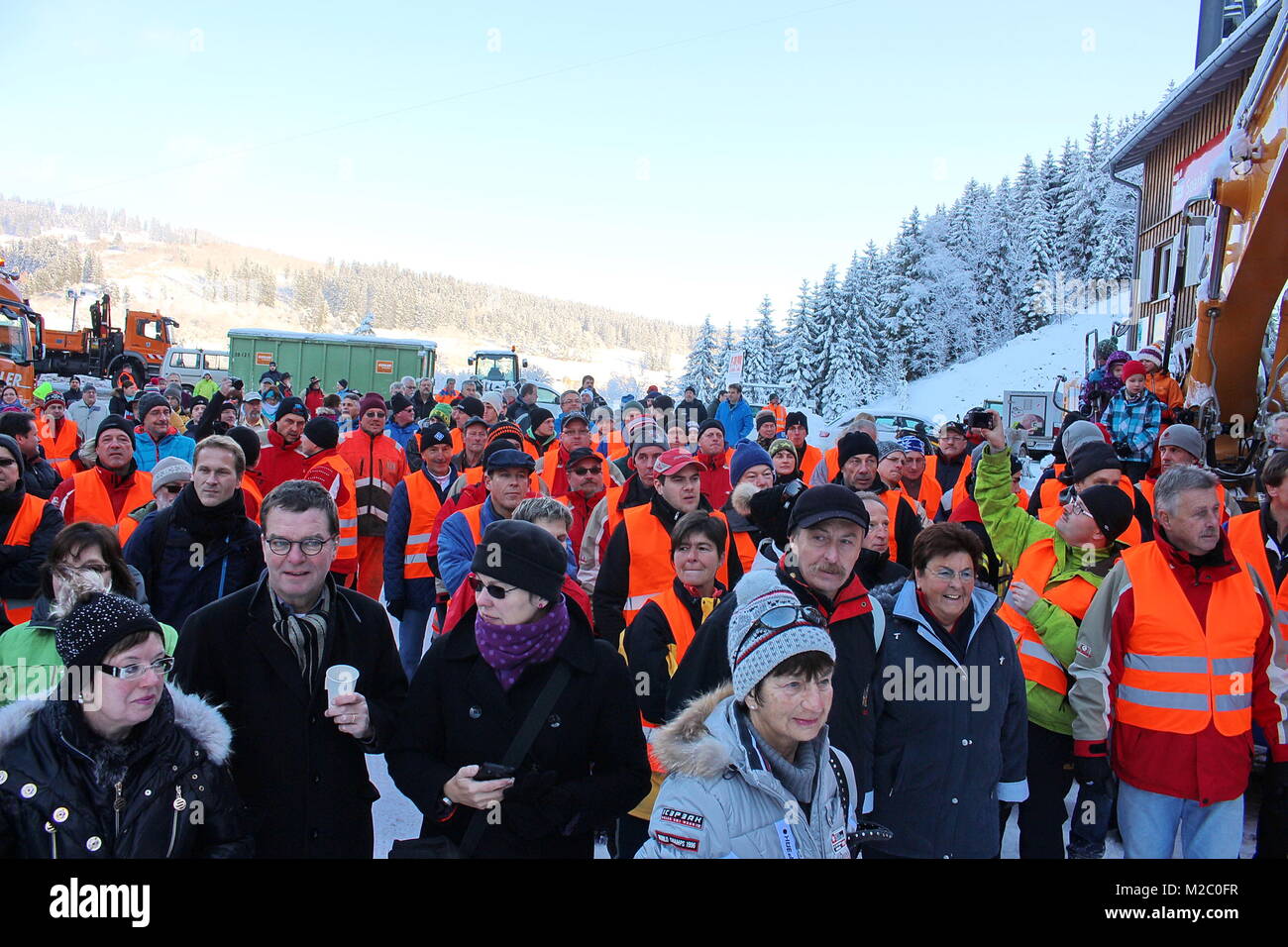 Gespannter Blick der Schaulustigen zum Schwarzwaldgletscher - Vor Schaulustigen zahlreichen wurde am Samstag (30.11.2013) Schmiedsbachtal im an der Hochfirstschanze der Schwarzwaldgletscher von Titisee-Neustadt geöffnet. Mit dem Schnee vom vergangenen inverno, der unter Styroporplatten, Sägemehl und Plastikfolien übersommert hat, wird jetzt die Hochfirstschanze mit Schnee belegt. Dort werden vom 13. bis 15. Dezember 2013 wieder zwei FIS Weltcup-Skispringen ausgetragen. Der zehn Meter hohe und 65 Meter lange Schneeberg umfasst etwa 7.000 Kubikmeter. Foto Stock