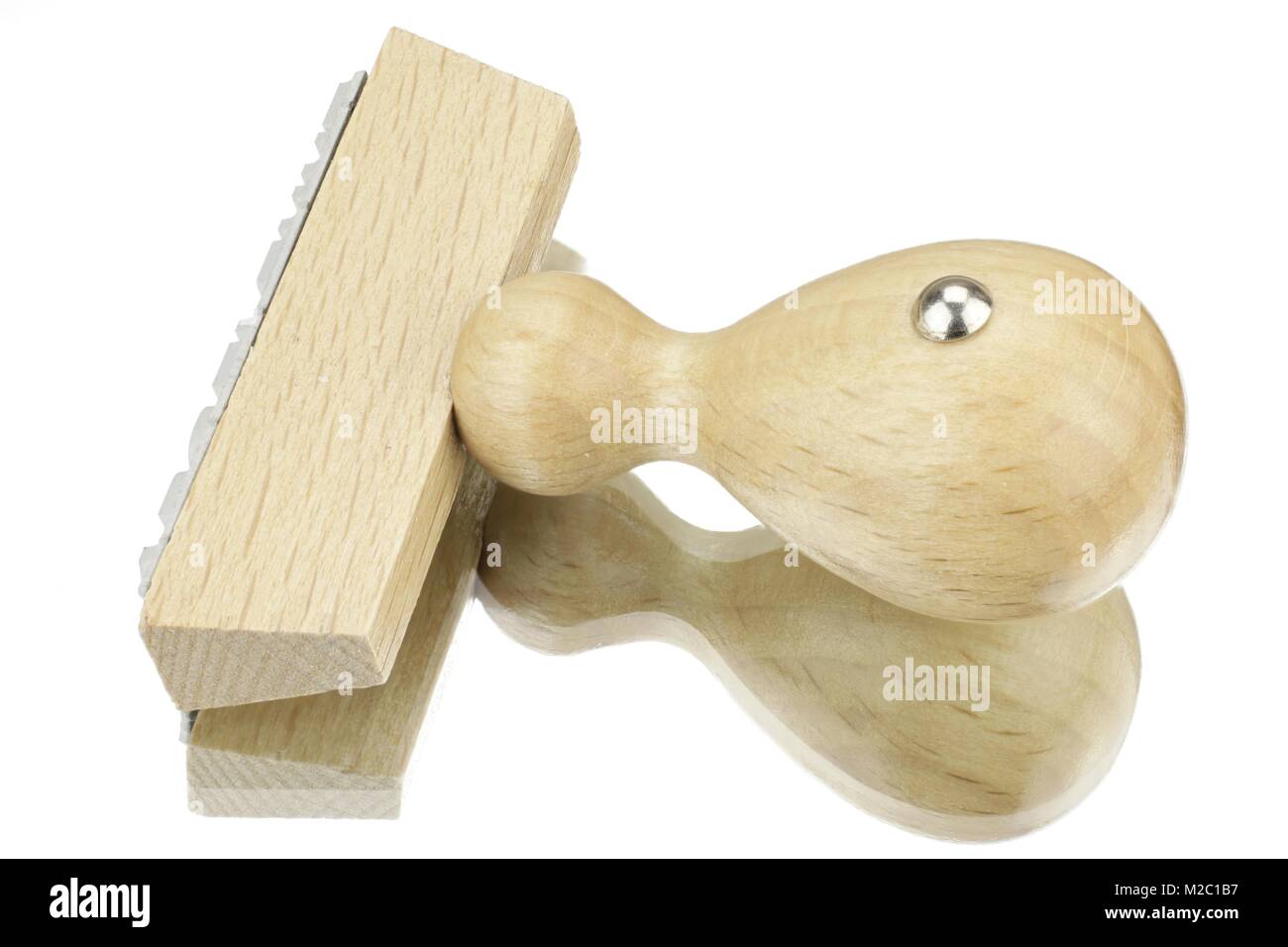 Francobollo di legno contro uno sfondo bianco con la riflessione Foto Stock