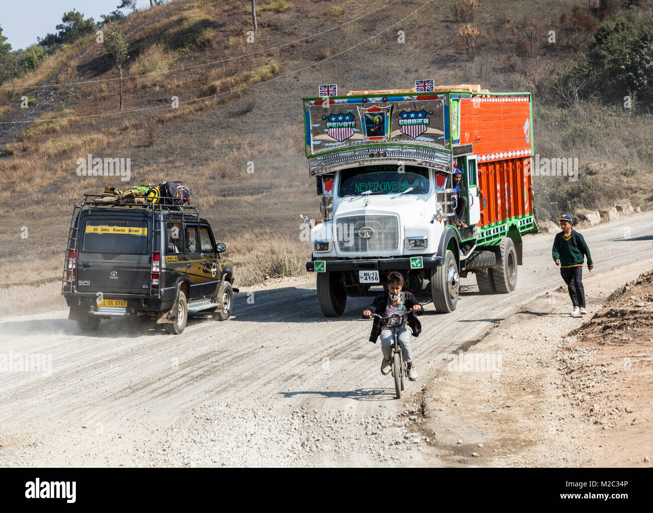 Ragazzo sulla bicicletta in strada con il traffico, Jowai, Meghalaya, India Foto Stock