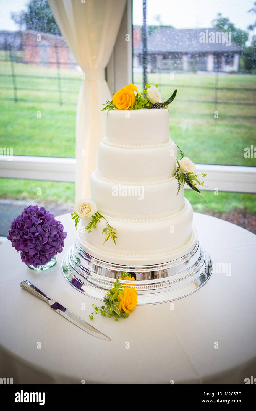Tre livelli di celebrazione torta decorata con fiori freschi Foto Stock