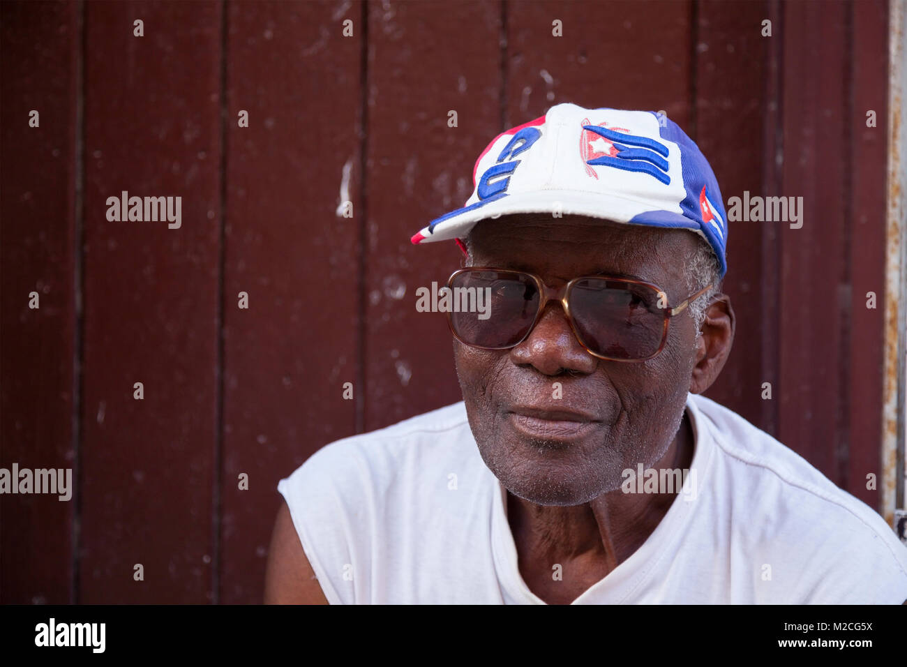 Un uomo cubano indossando un cubano di cappello e occhiali da sole a l'Avana, Cuba. Foto Stock