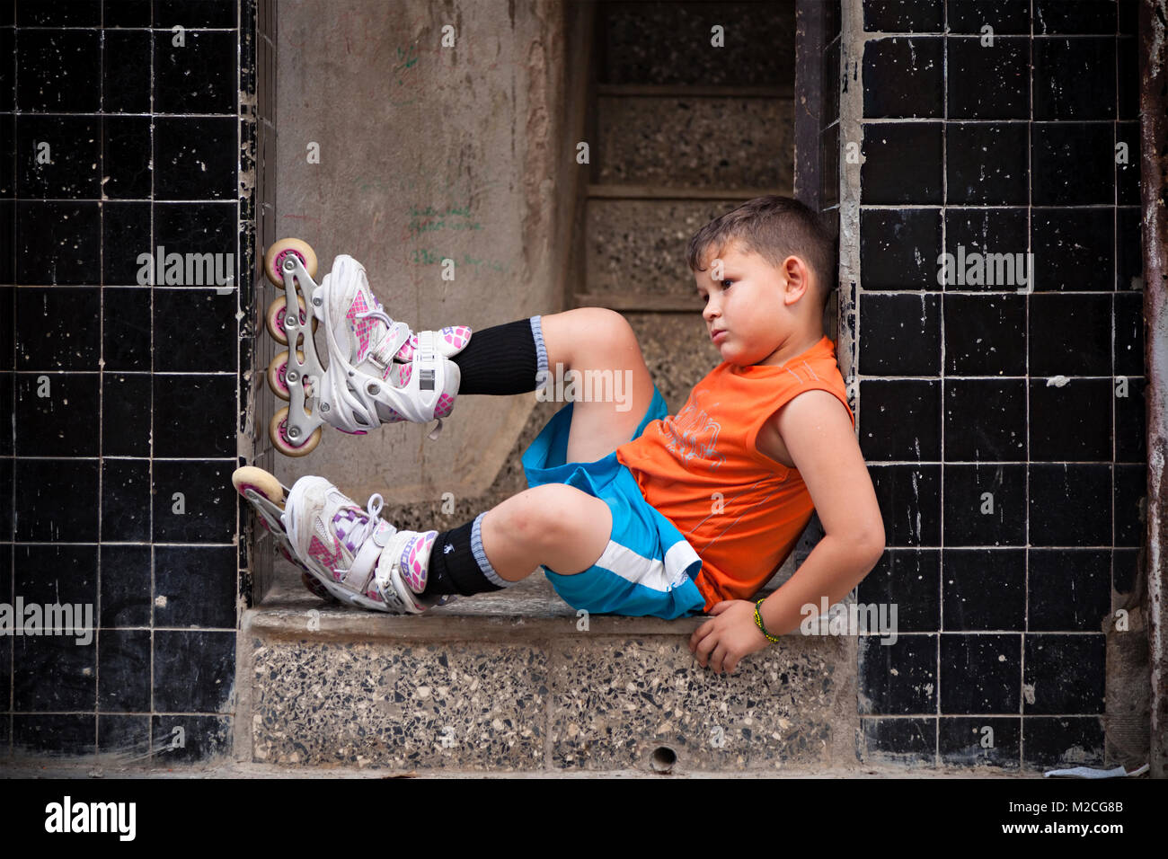 Un bambino cubano indossando le lame del rullo a l'Avana, Cuba. Foto Stock
