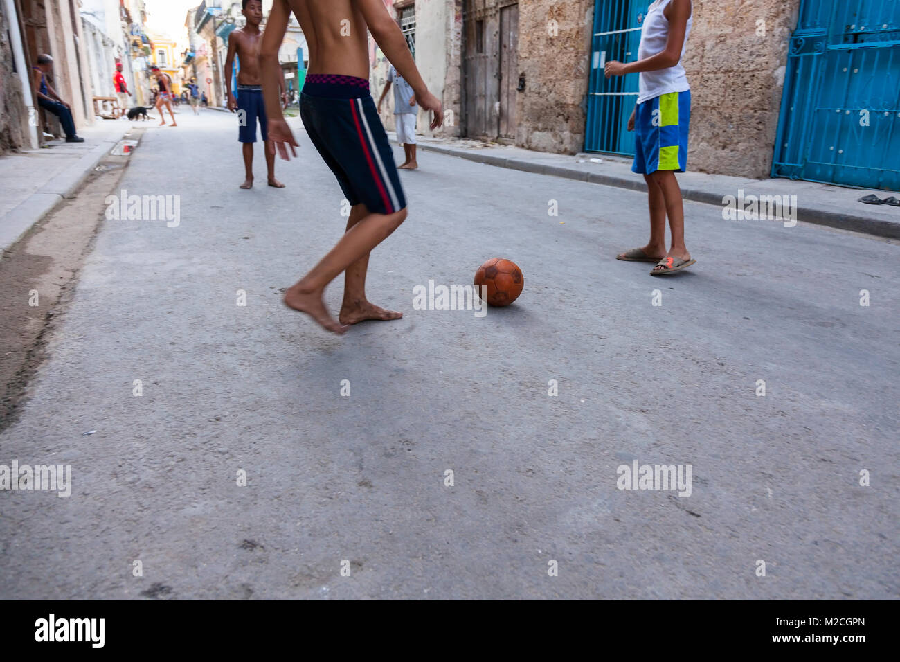 I bambini cubani che giocano a calcio o di calcio in strada. L'Avana, Cuba. Foto Stock