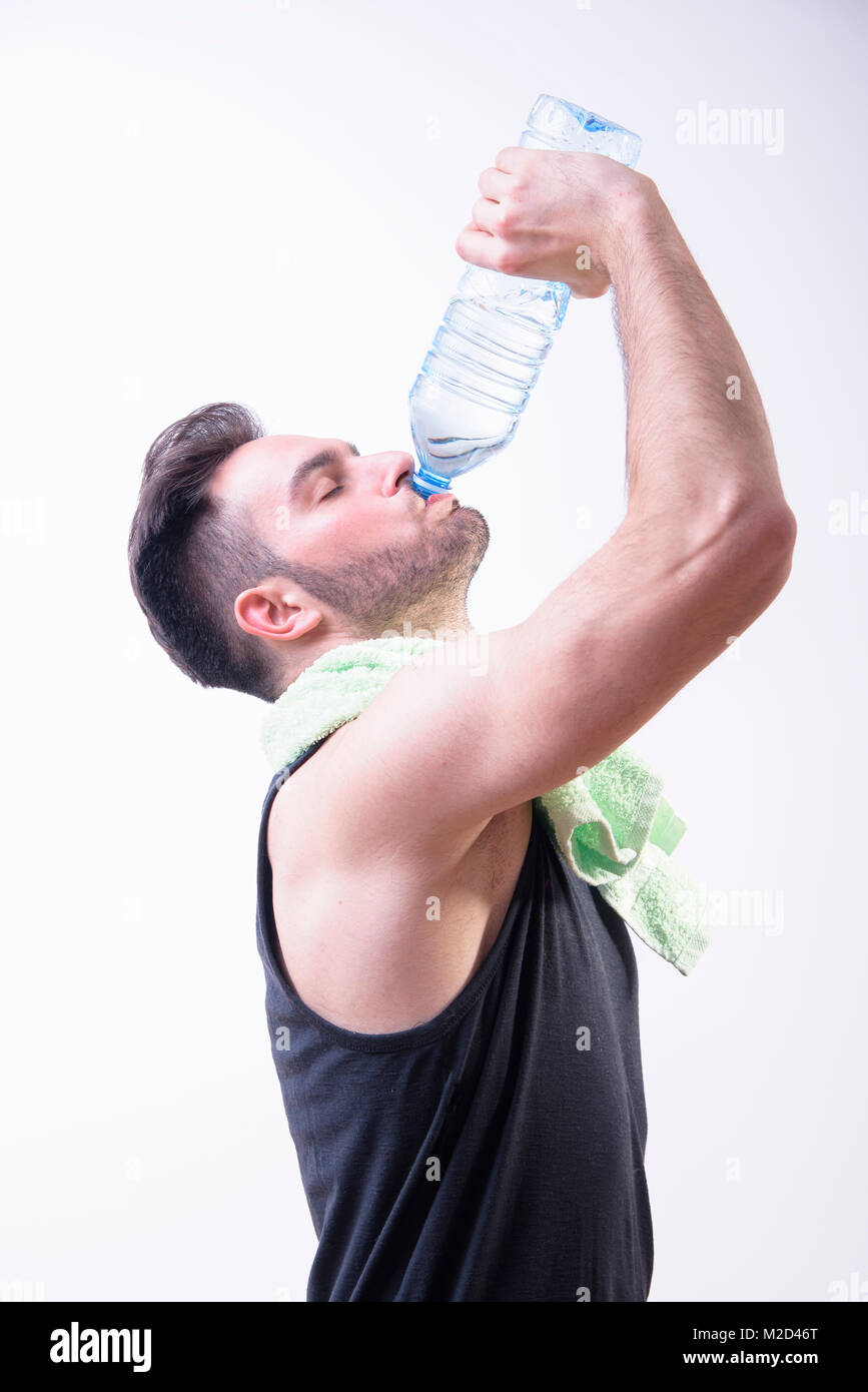 Atheltic uomo sportivo acqua potabile da una bottiglia dopo il duro allenamento Foto Stock