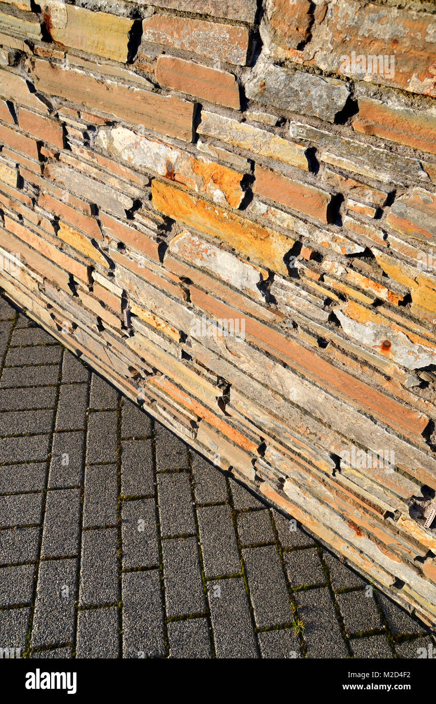 Abstract il contrasto del vecchio muro di pietra con moderni cemento mattoni di terra Foto Stock