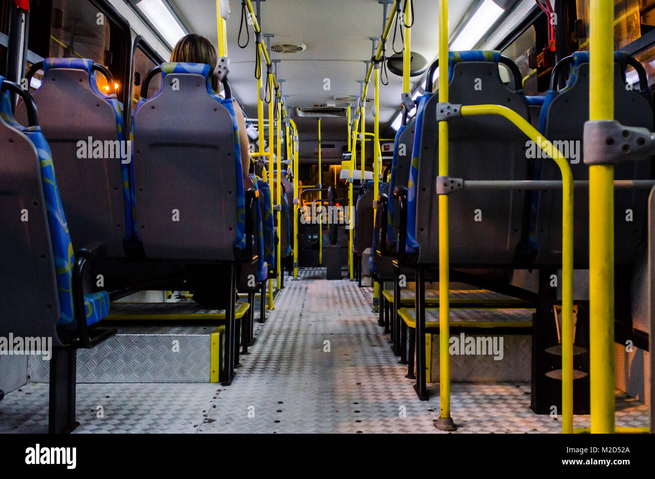 Interno di un vuoto bus collettivo di notte visto dal fondo sedie Foto Stock