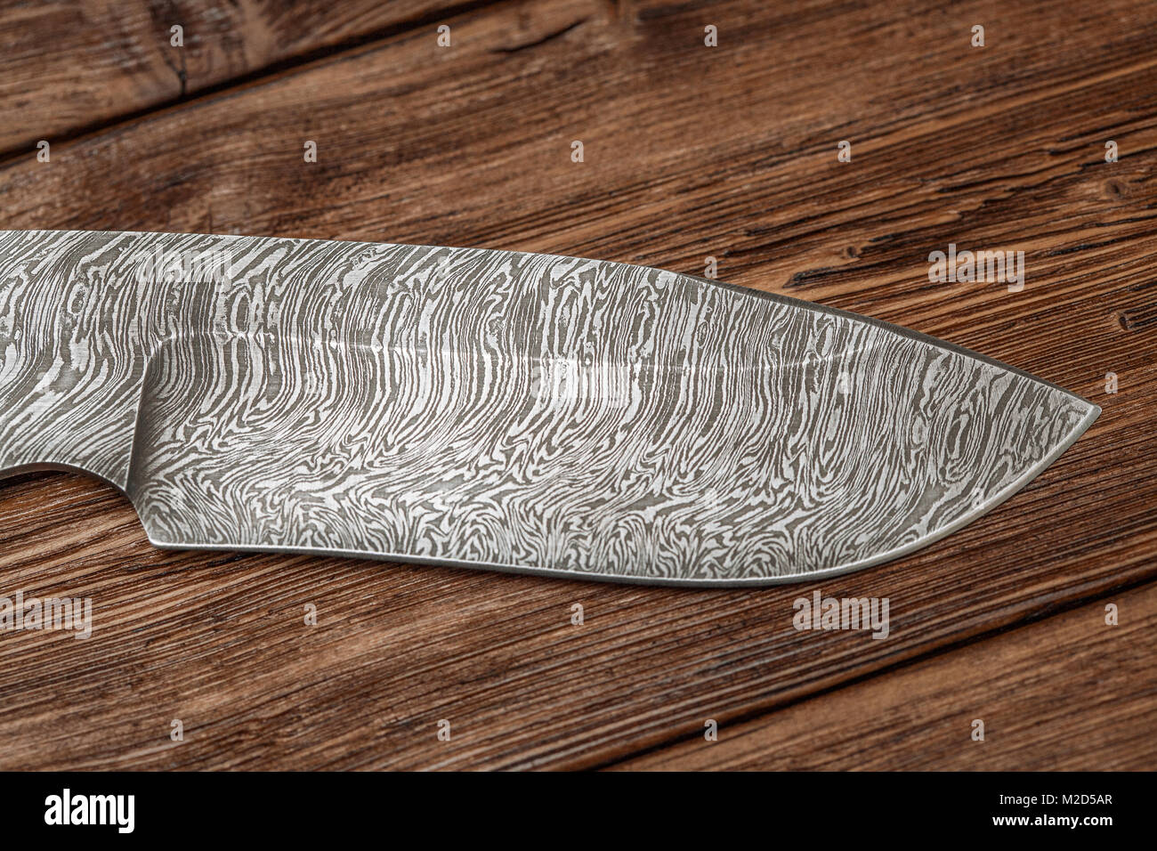 La caccia a Damasco Coltello in acciaio realizzati a mano su sfondo di legno, primo piano Foto Stock