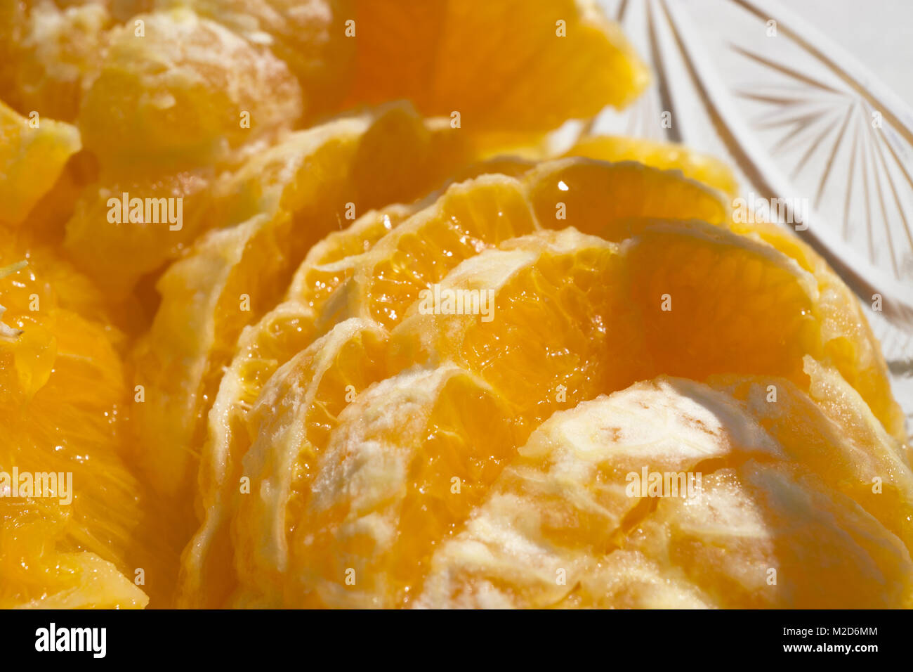 Primo piano di fettine di arance in un recipiente di vetro al sole. Foto Stock