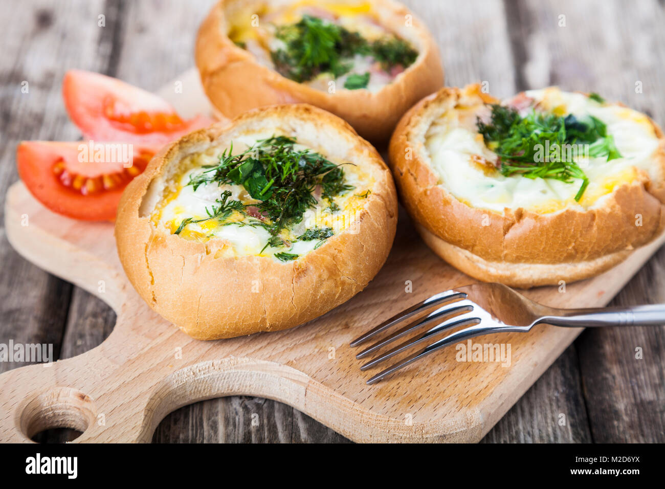 Uova strapazzate con formaggio e bacon in un panino. Una gustosa prima colazione. Foto Stock