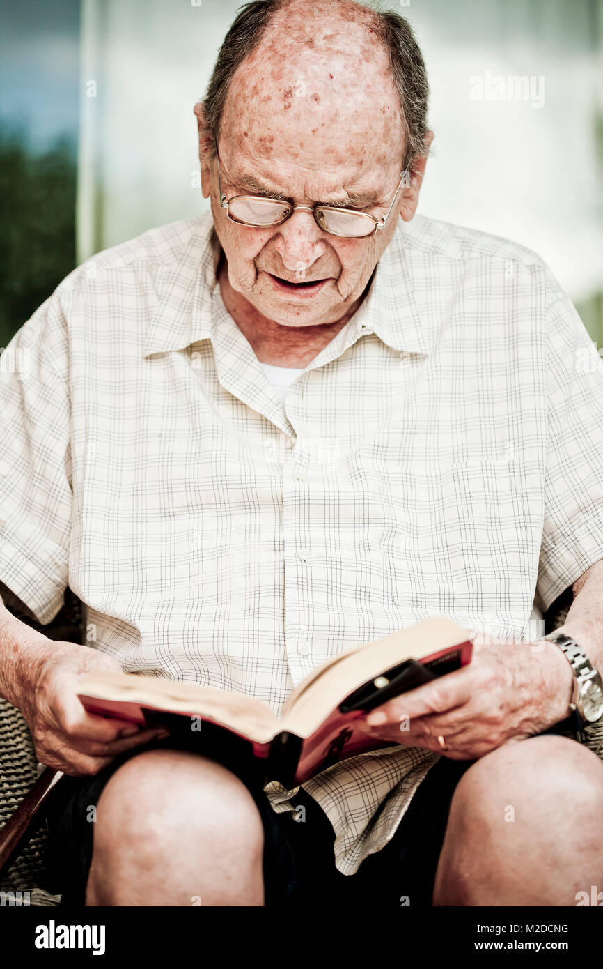 Ritratto di un uomo vecchio come lui legge un libro Foto Stock