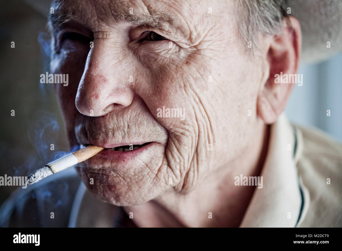 Un vecchio uomo di fumare Foto Stock