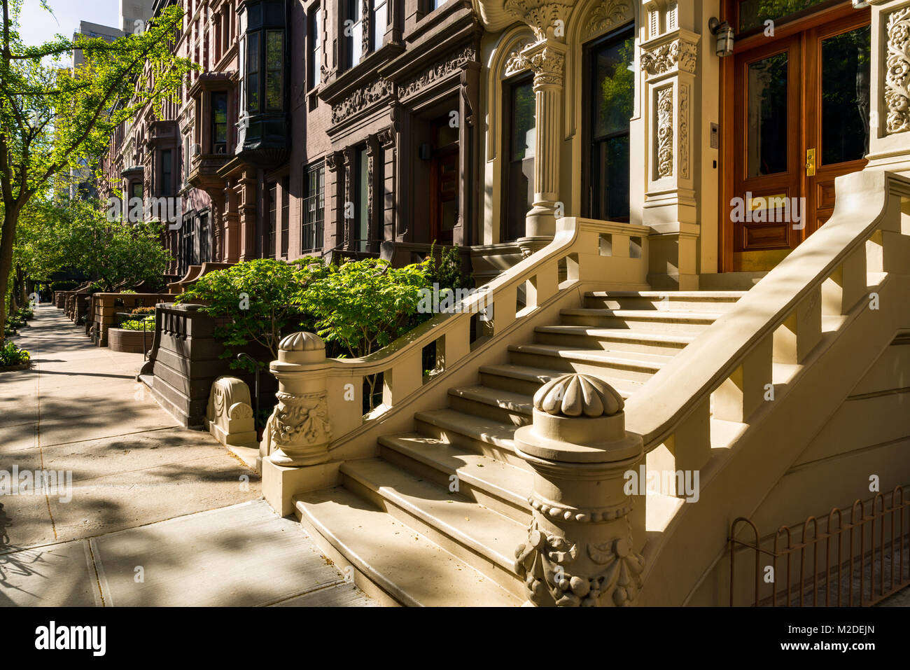 Case di arenaria con gradini di casa ed ornamento nella luce del mattino. Upper West Side Street, Manhattan New York City Foto Stock