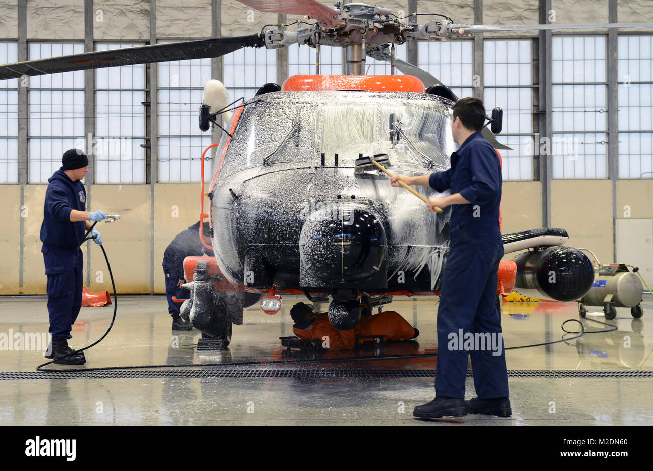La guardia costiera della stazione aria Kodiak aviatori lavare un MH-60 elicottero Jayhawk in Hangar 3 in corrispondenza della stazione di aria di Kodiak, Alaska, Gen 3, 2018. Regolare manutenzione di aeromobili, tra cui un aeromobile lavaggio, è una parte importante di garantire Coast Guard beni siano privi di sporcizia e detriti e il sale residuo di acqua che può portare a fenomeni di corrosione e di ostacolare la corretta delle prestazioni. Stati Uniti Coast Guard Foto Stock