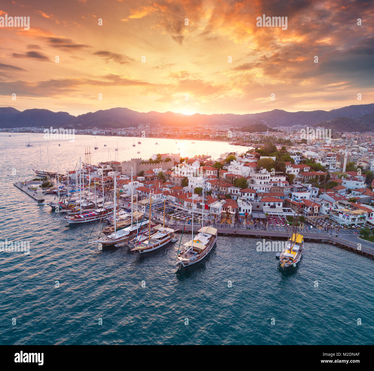 Vista aerea di barche e yacht e la bella architettura al tramonto a Marmaris, Turchia. Paesaggio con barche in marina bay, mare, città, montagne, co Foto Stock