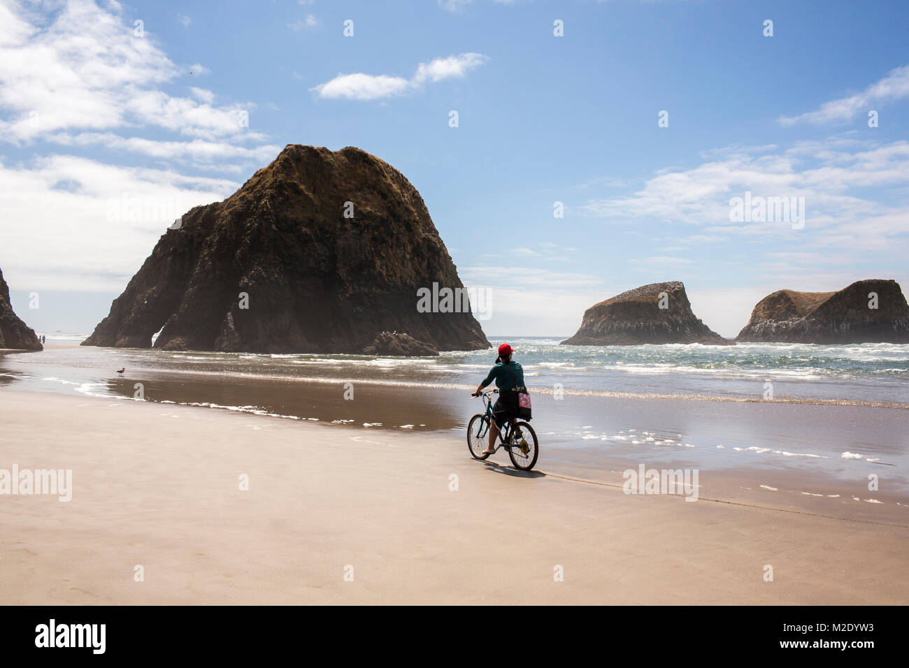 La donna caucasica Bicicletta Equitazione sulla spiaggia Foto Stock