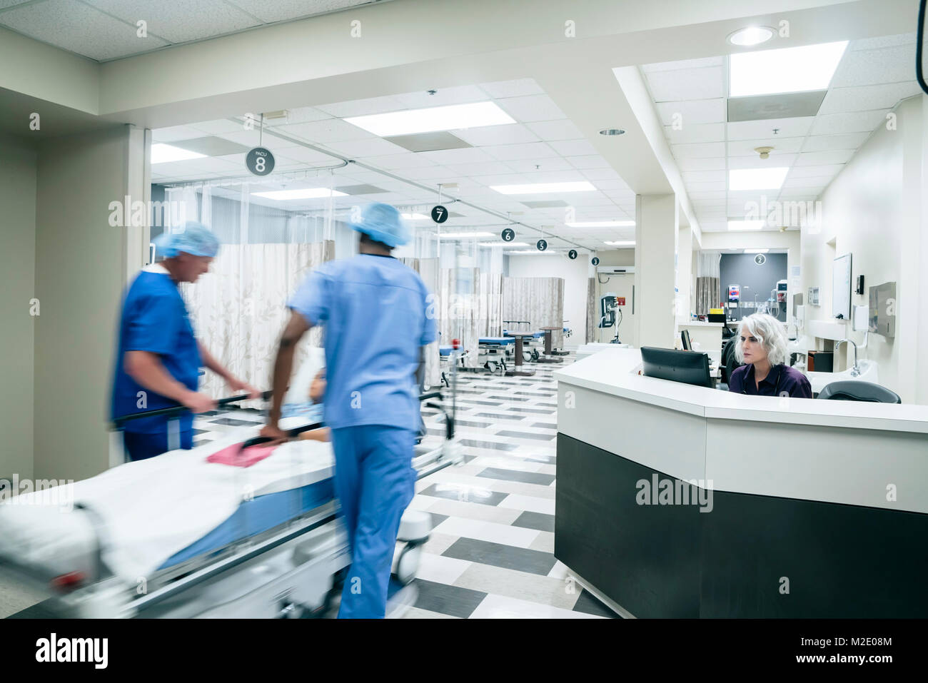I medici spingendo il paziente in ospedale gurney Foto Stock
