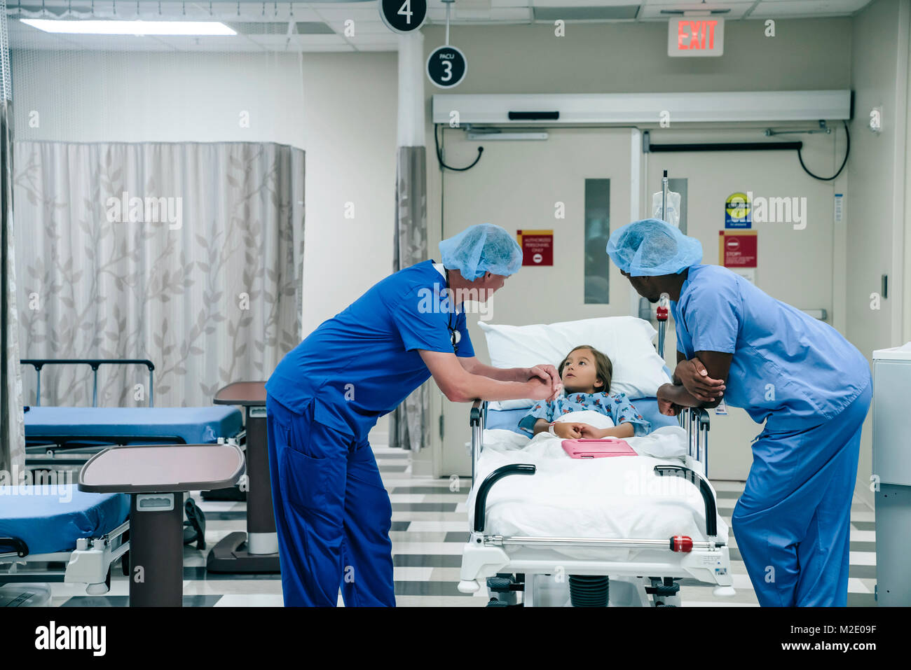 I medici a parlare con la ragazza in ospedale gurney Foto Stock