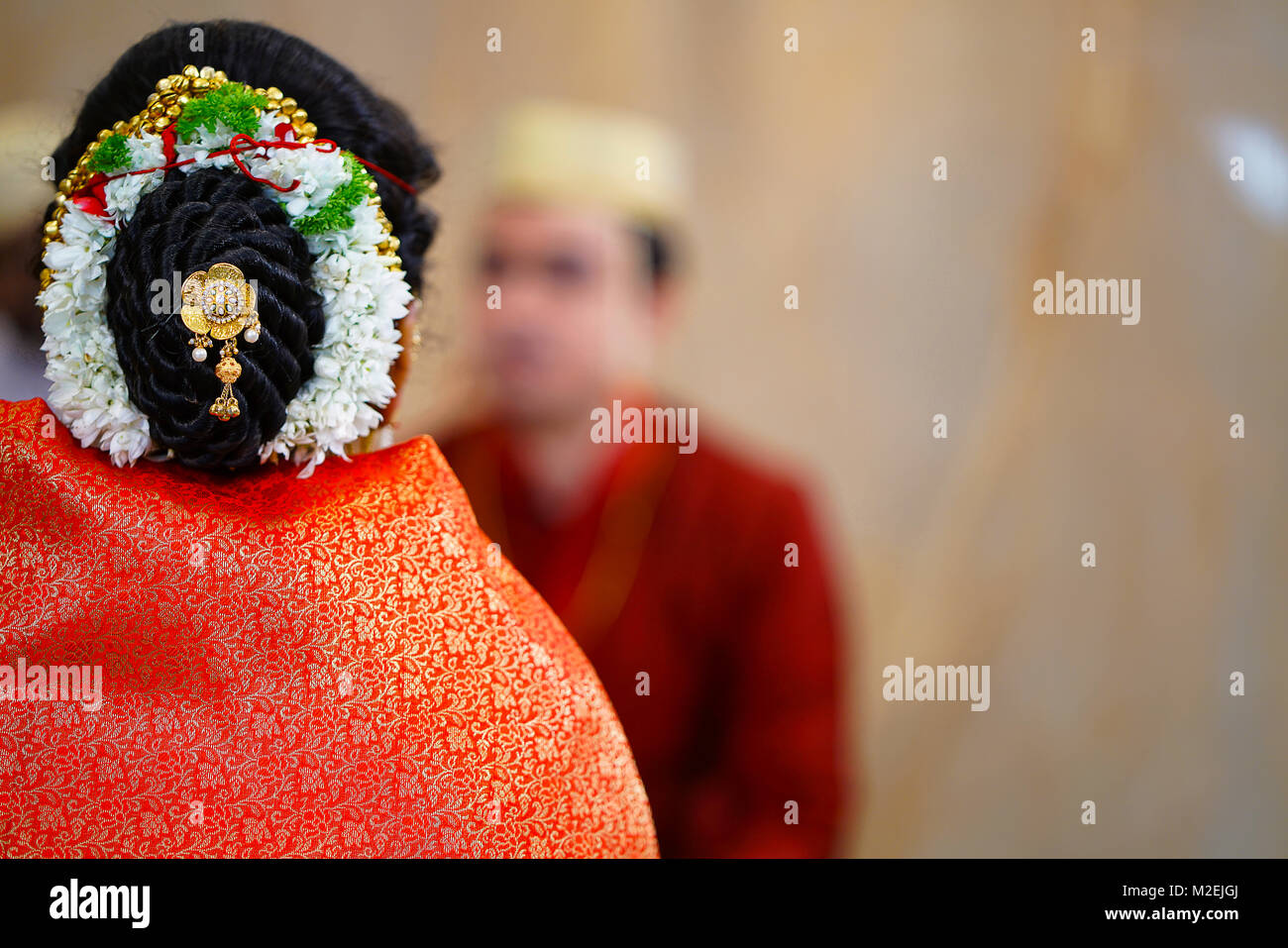 Tipica tradizionale stile dei capelli di un Indù, femmina con i capelli formando una pagnotta. Con motivi floreali garlanding intorno a. Foto Stock