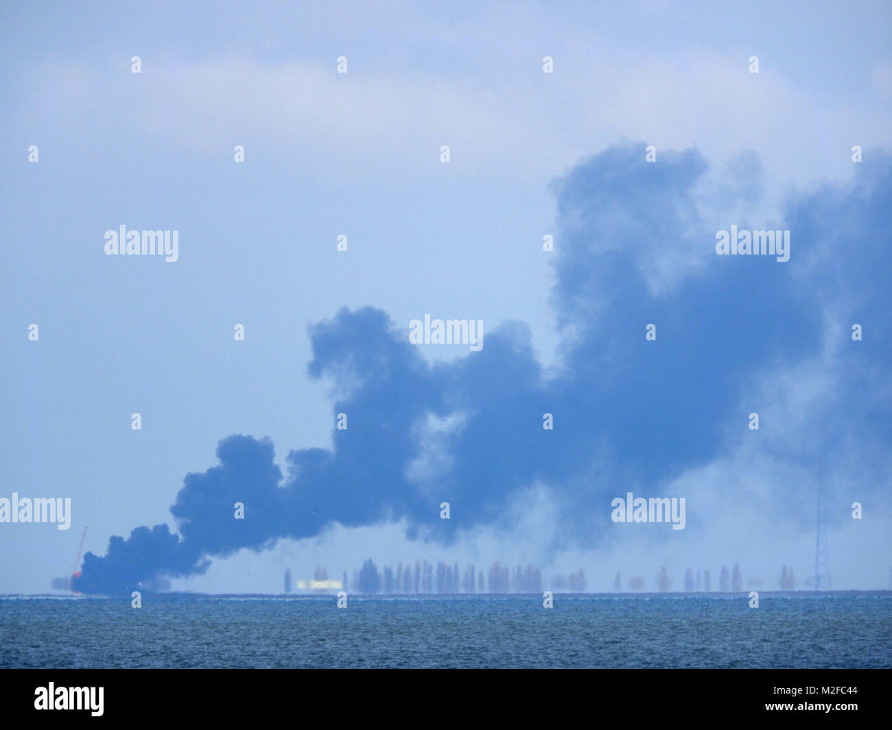 Sheerness, Kent, Regno Unito. 7 febbraio, 2018. Un grande pennacchio di fumo al ministro della Difesa Shoeburyness sito in Essex, come visto da di Sheerness sull'altro lato dell'estuario del Tamigi nel Kent. Credito: James Bell/Alamy Live News Foto Stock