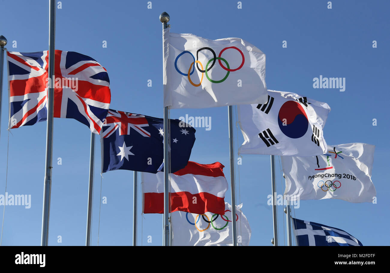 Pyeongchang, Corea del Sud. 07 feb 2018. La bandiera olimpica (L), il sud coreano bandiera (C) come pure la bandiera dell'Pyeongchang 2018 Olimpiadi invernali, sventolando nel vento di fronte allo Stadio Olimpico di Pyeongchang, Corea del Sud, 07 febbraio 2018. Il Pyeongchang 2018 Olimpiadi invernali si svolgerà tra il 09 e 25 febbraio. Credito: Tobias Hase/dpa/Alamy Live News Foto Stock
